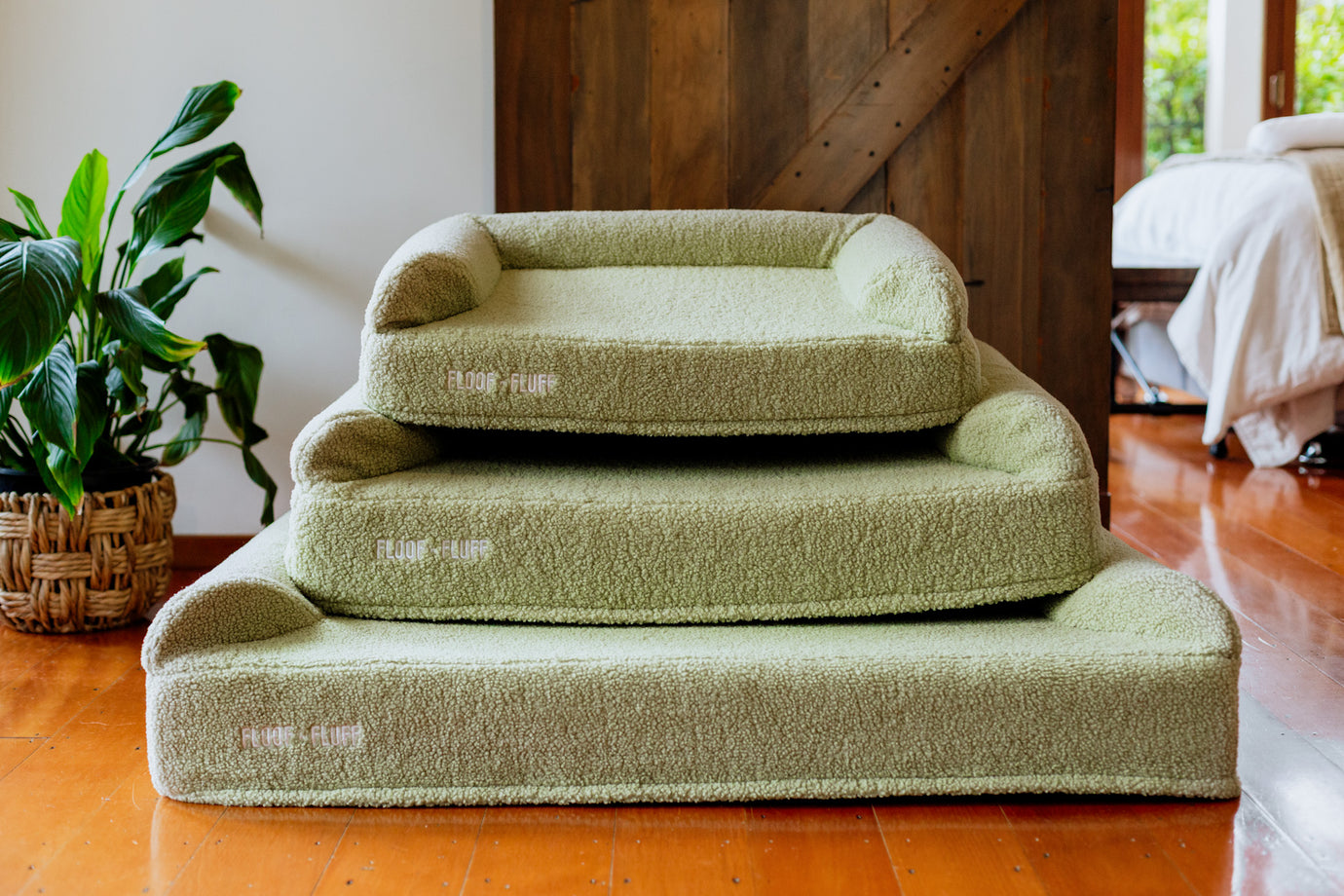 Sage green floof n fluff dog beds stacked on each other to display size difference 